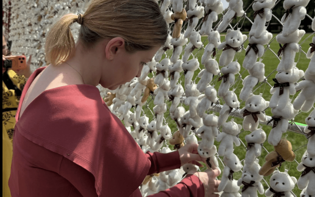 Olga Stefanishyna, embajadora de Ucrania en Estados Unidos, colocando un oso de peluche en el National Mall de Washington como parte de una protesta por el secuestro de niños ucranianos por parte de Rusia.