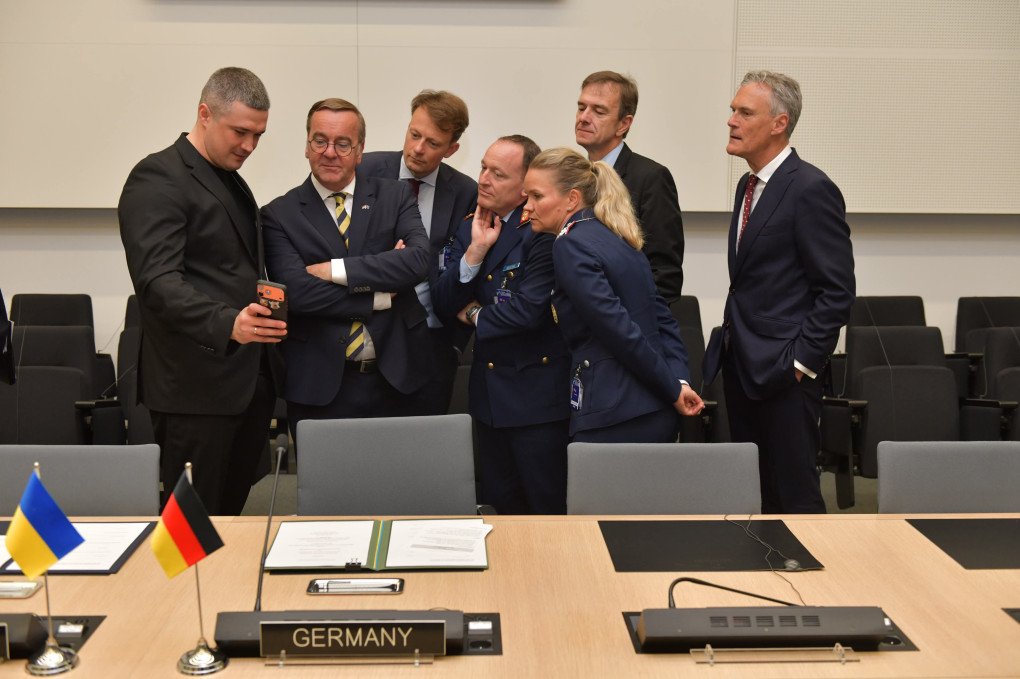 Ukrainian Defense Minister Mykhailo Fedorov (L) shows photos of the aftermath of a Ukrainain drone strike on a Russian capital to Boris Pistorius (2nd R) and other NATO officials in Brussels on June 18, 2026. (Source: Mykhailo Fedorov) Ukrainian Defense Minister Mykhailo Fedorov (L) shows photos of the aftermath of a Ukrainain drone strike on a Russian capital to Boris Pistorius (2nd R) and other NATO officials in Brussels on June 18, 2026.