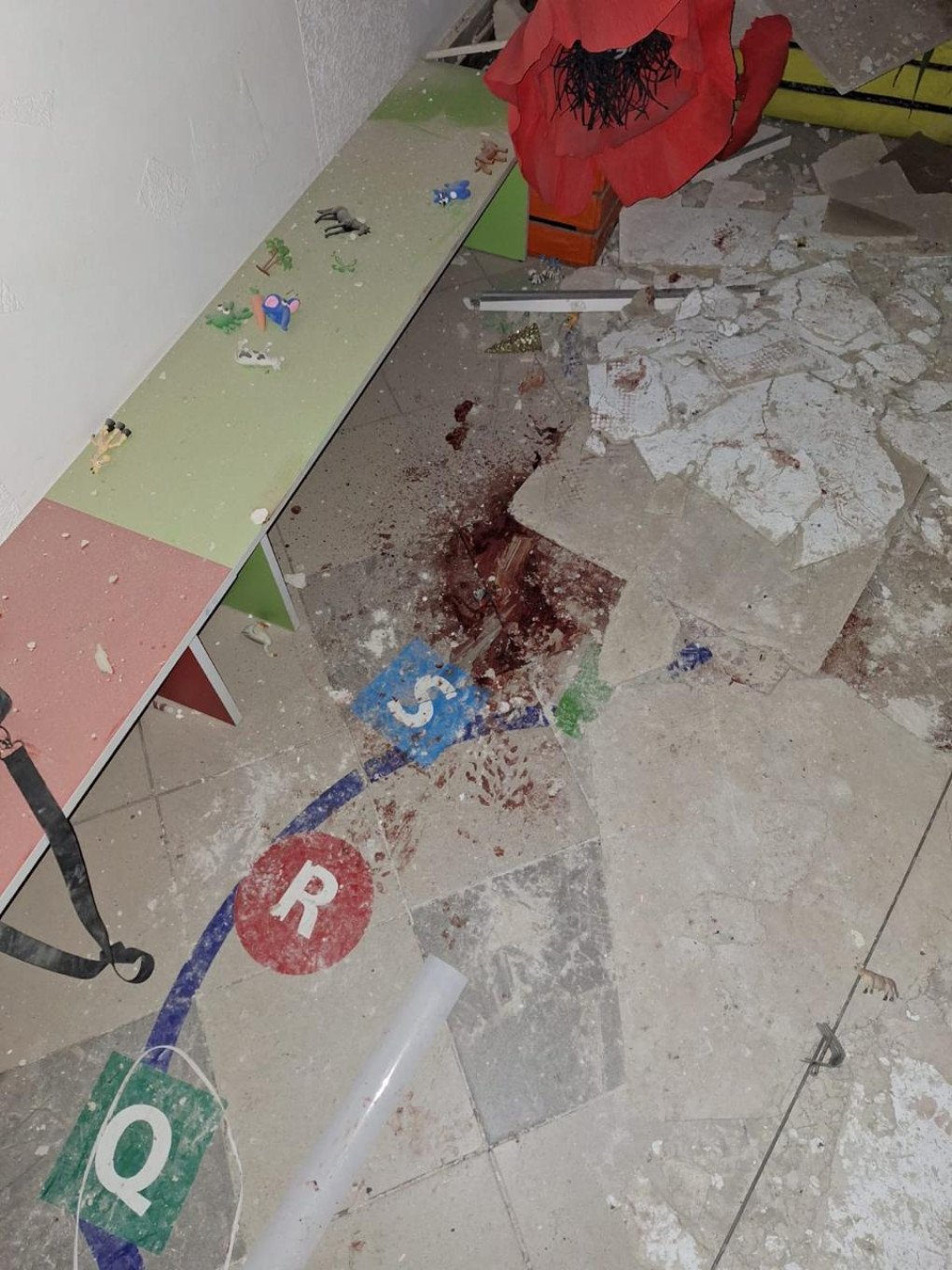 Blood marks the floor amid broken tiles and debris inside the kindergarten following the drone strike. (Source: SBU)
