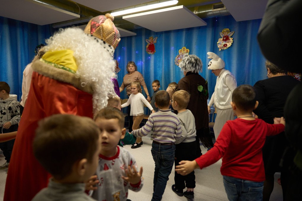 Children and teachers hold hands and dance during the celebration of St. Nicholas Day at one of the underground kindergartens in the Zaporizhzhia region, Ukraine, December 2025. Photo by Mykyta Shandyba / UNITED24 Media.