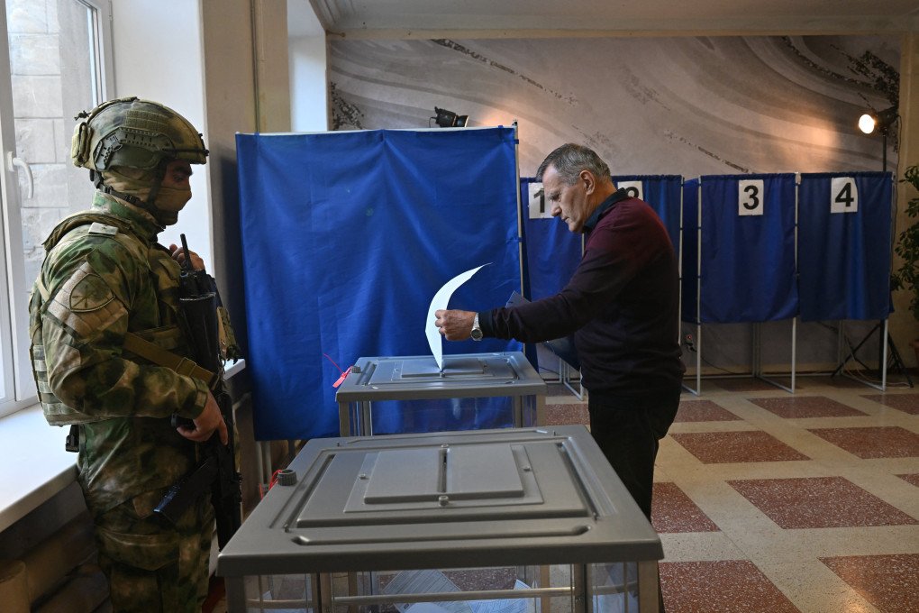 A man casts his ballot as an armed Russian serviceman stands beside him at a polling station in occupied Donetsk, Ukraine, during Russia’s parliamentary election on September 18, 2026. Russia’s organization of voting in the temporarily occupied territories of Ukraine violates international law. (Photo by AFP via Getty Images) A man casts his ballot as an armed Russian serviceman stands beside him at a polling station in occupied Donetsk, Ukraine, during Russia’s parliamentary election on September 18, 2026. Russia’s organization of voting in the temporarily occupied territories of Ukraine violates international law. (Photo by AFP via Getty Images)