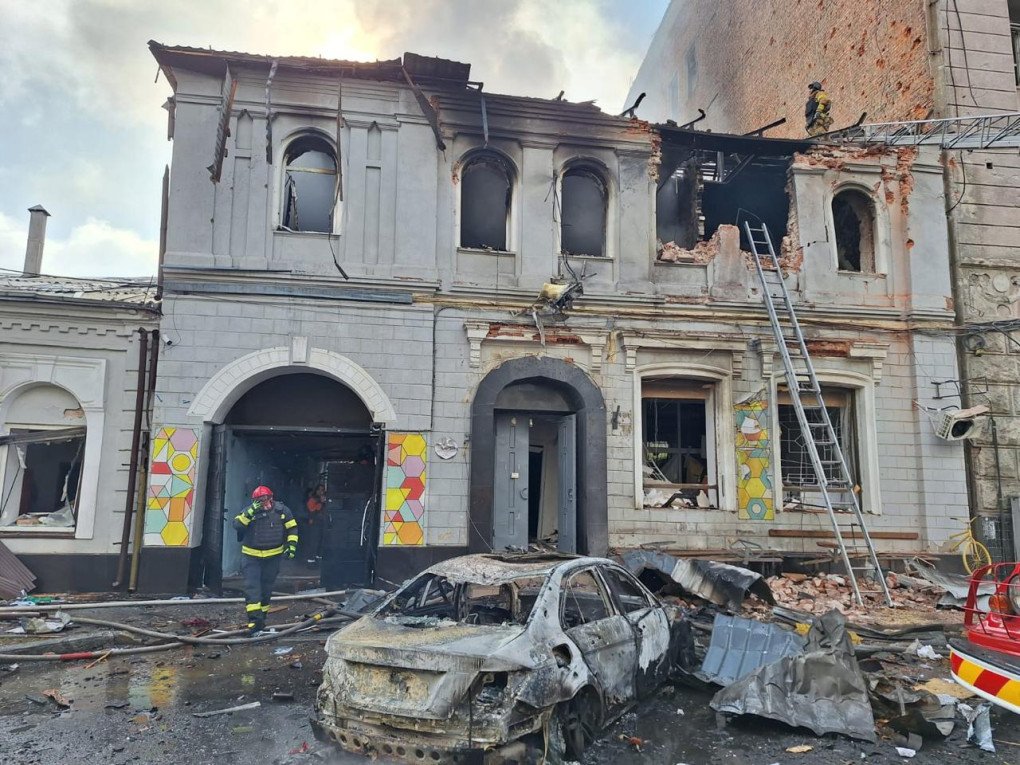 Emergency responders work at the site of a Russian drone strike that hit a private kindergarten in Kharkiv’s Kholodnohirskyi district, severely damaging the building and nearby vehicles. (Source: SBU)