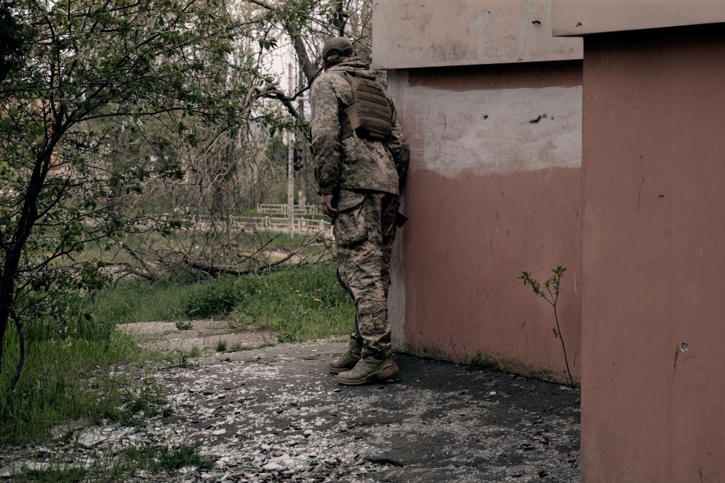 Serhii observes around a corner before moving forward. Kherson, Ukraine, May 2026. Photo: Joshua Olley / UNITED24 Media.