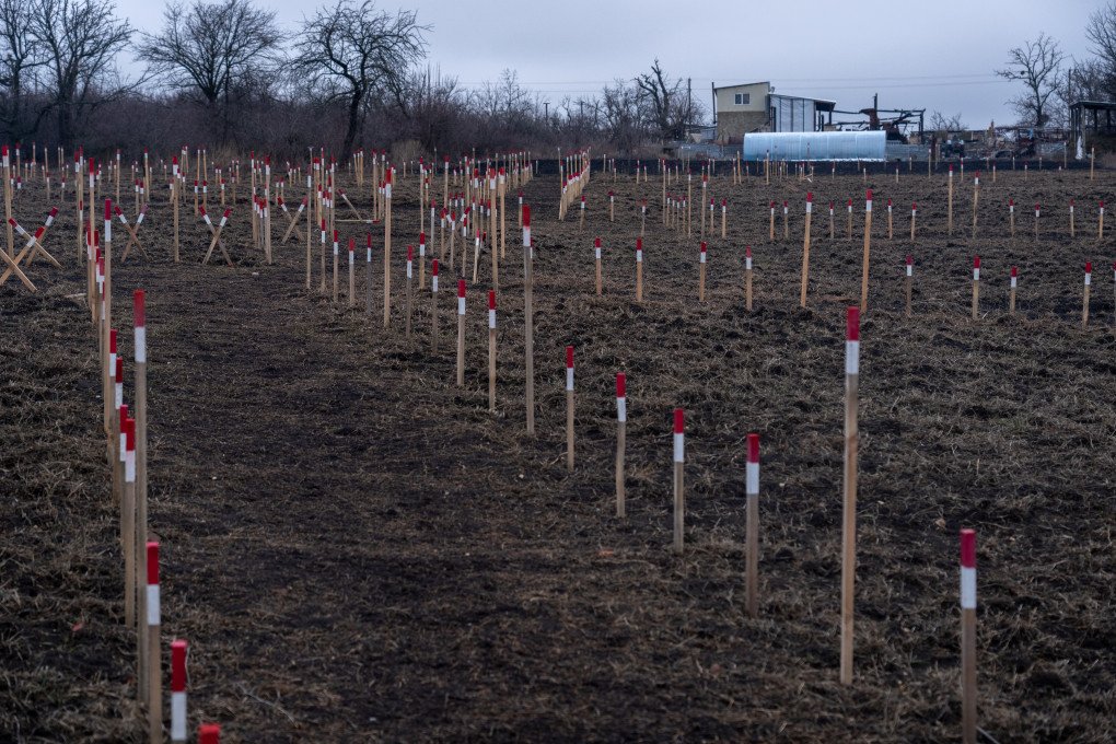 Markers of humanitarian demining surround the village. Ihor’s house is visible in the distance. Photo: Oleksii Filippov Markers of humanitarian demining surround the village. Ihor’s house is visible in the distance. Photo: Oleksii Filippov