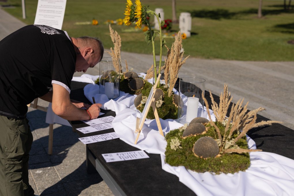 A man writes a name on a remembrance card. (Photo: Vic Bakin/UNITED24 Media) A man writes a name on a remembrance card. (Photo: Vic Bakin/UNITED24 Media)