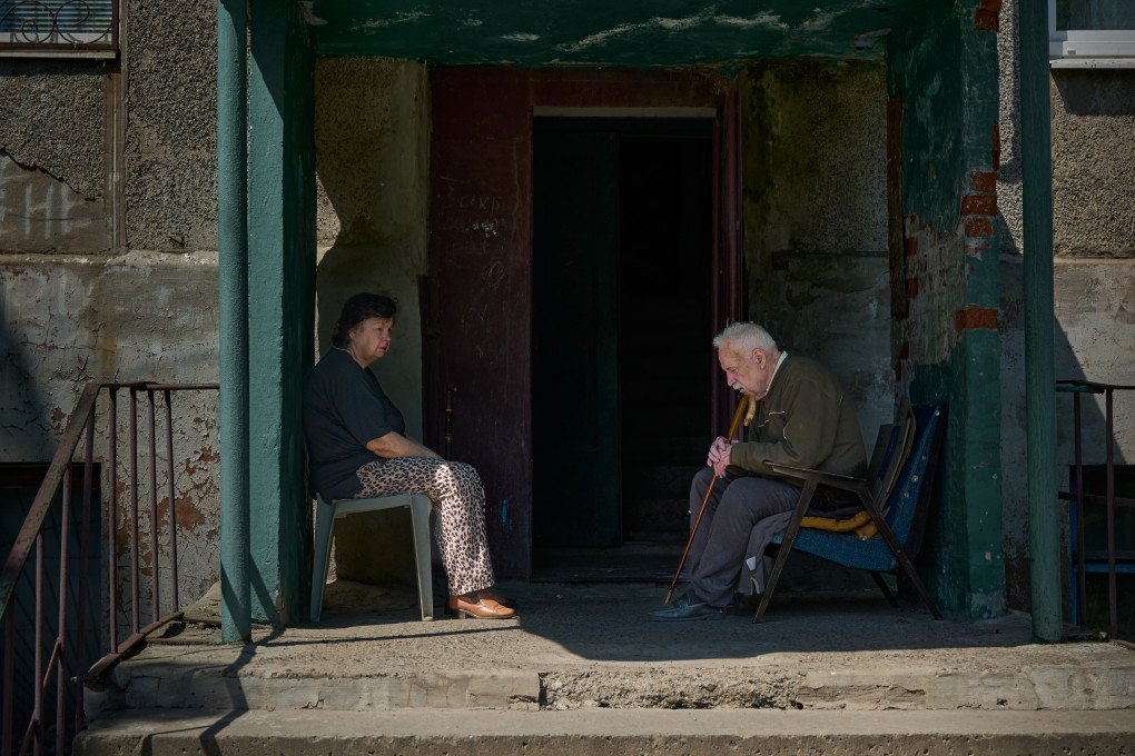 Residents of Druzhkivka sit outside their apartment building entrance. (Photo: Mykyta Shandyba/ UNITED24 Media)