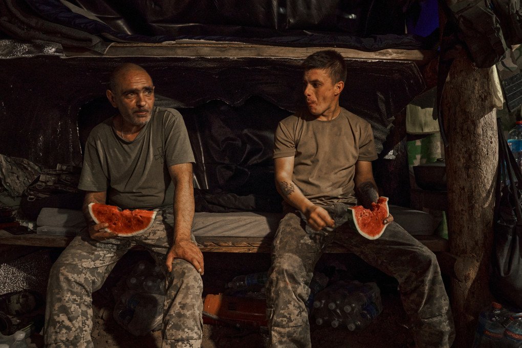 Jimmy and Serhii of the 28th Brigade share a watermelon in their blindage. Kostiantynivka, August 2025. Photo: Josh Olley/UNITED24 Media