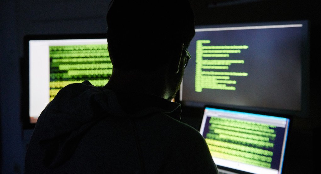 A man sits in front of three screens with text. (Source: Getty Images) A man sits in front of three screens with text. (Source: Getty Images)
