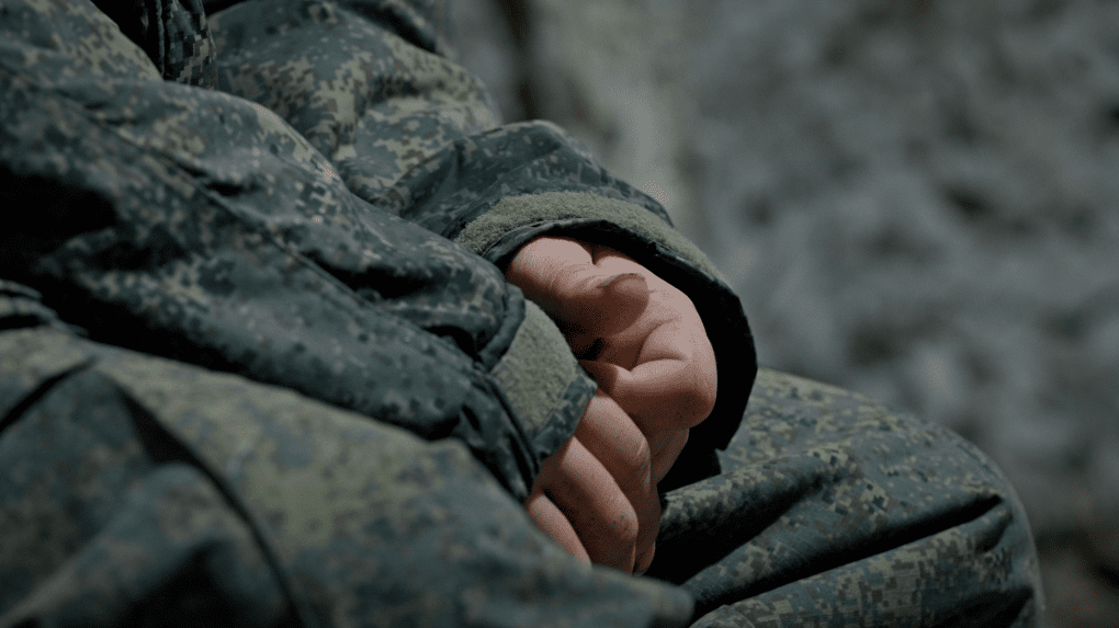 A close-up of Arash Darbandi’s hands in a Russian military uniform. Photo: UNITED24 Media