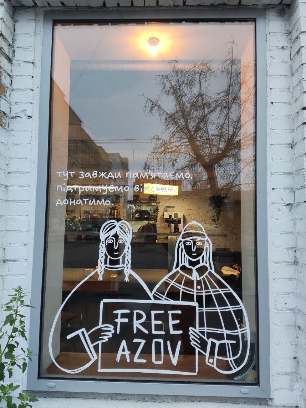 щиро (Sincerely) cafe with ‘Free Azov’ etched into the window which reads: Тут завжди пам'ятаємо підтримуємо військо донатимо—Here, we always remember, support the military, and donate. Kyiv, December 2025. Photo: UNITED24 Media