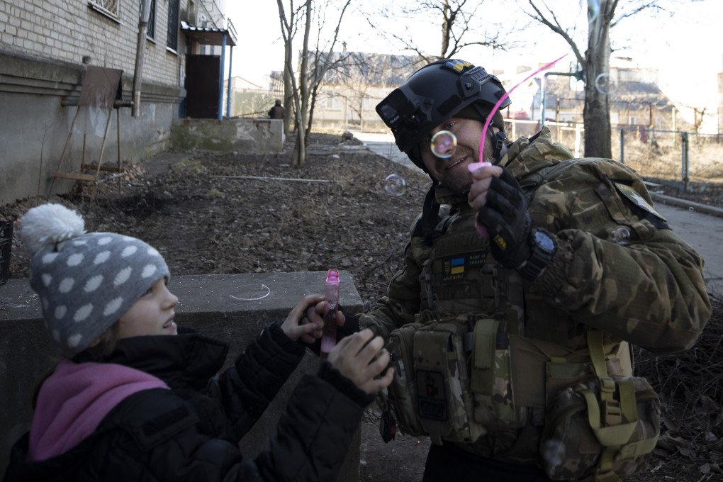 Anya, 7, plays with Ukrainian soldiers as she lives in a shelter with her family amid the war in Donetsk region, Ukraine on January 25, 2023. (Photo by Mustafa Ciftci via Getty Images)