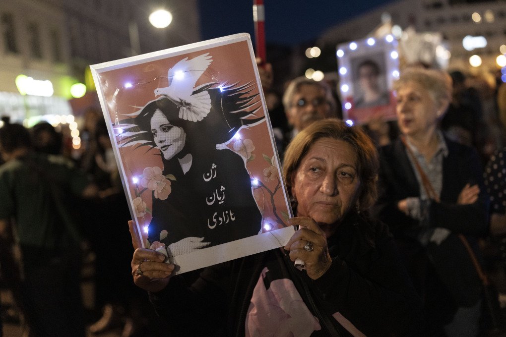 A demonstrator holds a picture of Mahsa Amini during an evening march to commemorate the first anniversary of the death of Mahsa Amini on September 15, 2023 in Berlin, Germany. (Photo by Maja Hitij/Getty Images)