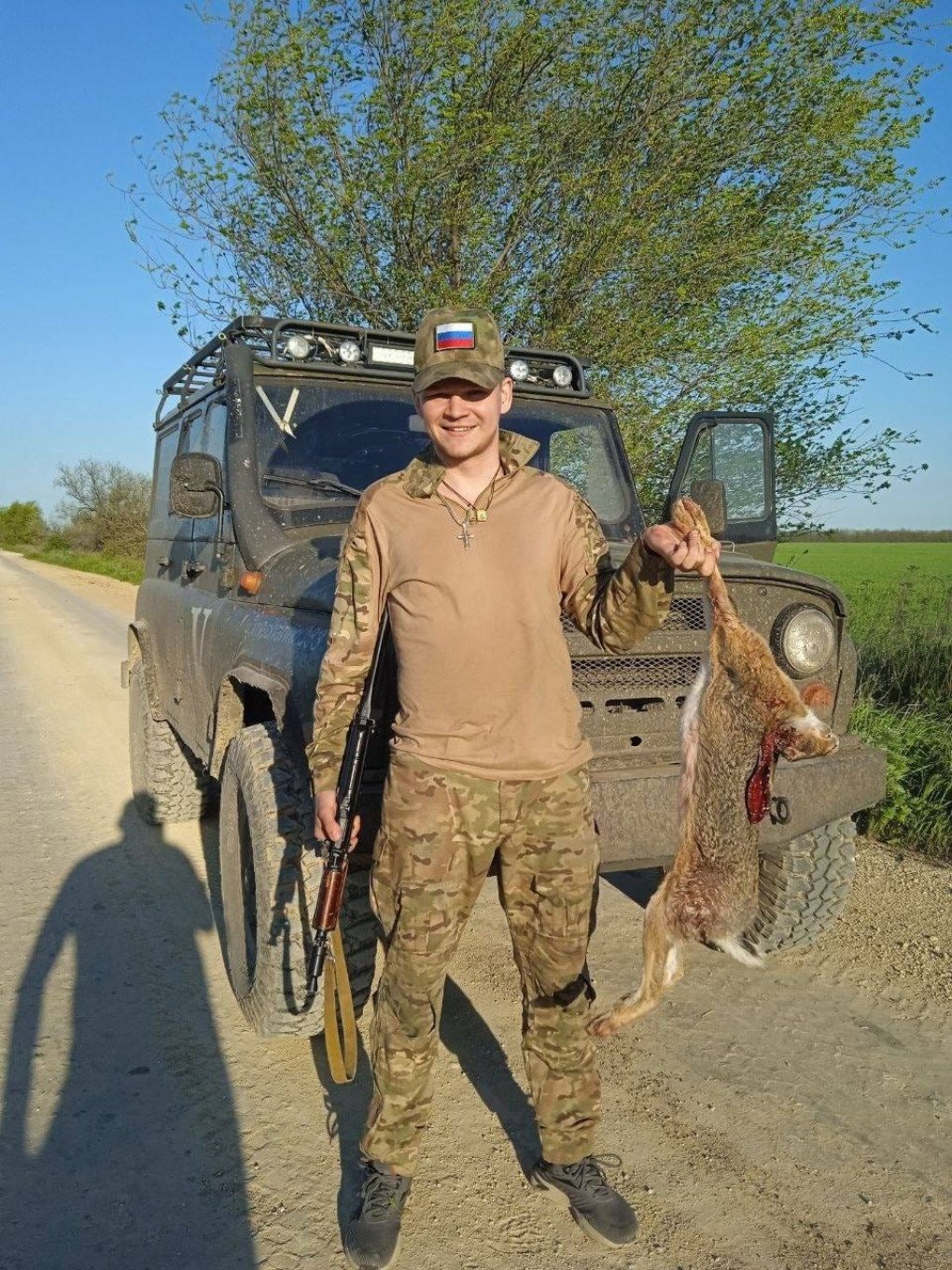 Russian soldier posing with a killed European hare. (Source: UAnimals/ Facebook)
