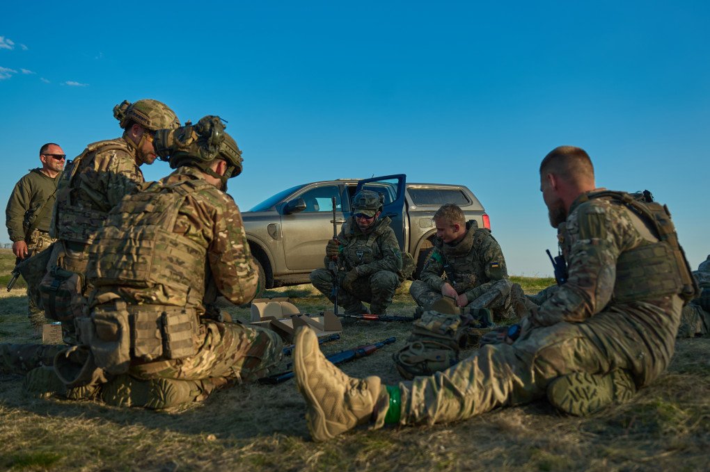 Entre simulacro y simulacro, los voluntarios extranjeros se reúnen en torno a armas y equipos para una sesión informativa sobre el terreno a cielo abierto en el este de Ucrania. Entre simulacro y simulacro, los voluntarios extranjeros se reúnen en torno a armas y equipos para una sesión informativa sobre el terreno a cielo abierto en el este de Ucrania.