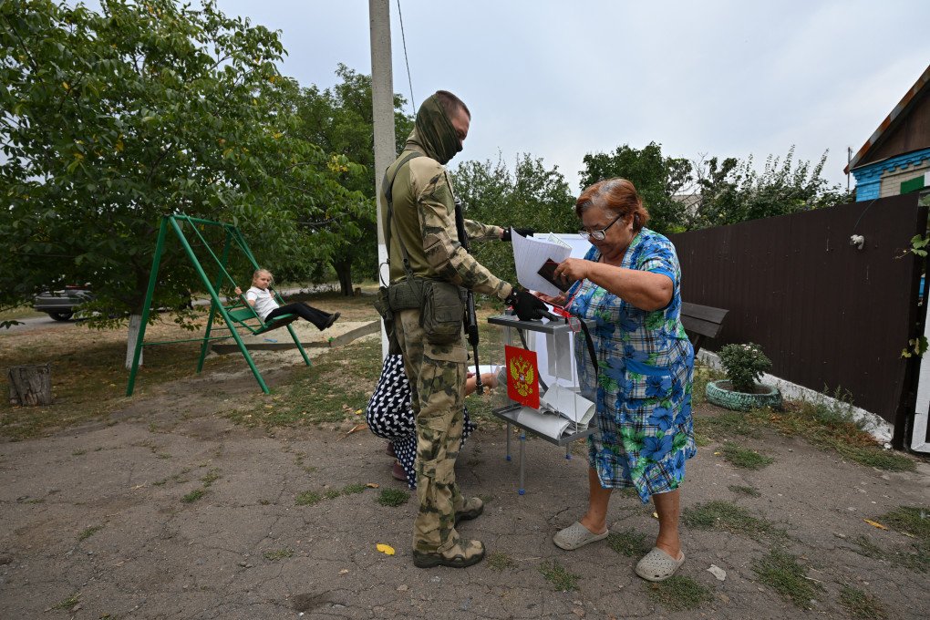 A woman casts her ballot into a mobile ballot box held by a Russian serviceman, who is accompaniyng members of a local election commission, during early voting in Russia's parliamentary election in the settlement of Verbovka in the Donetsk region, Russian-controlled Ukraine, on September 14, 2026. (Photo by AFP via Getty Images) A woman casts her ballot into a mobile ballot box held by a Russian serviceman, who is accompaniyng members of a local election commission, during early voting in Russia's parliamentary election in the settlement of Verbovka in the Donetsk region, Russian-controlled Ukraine, on September 14, 2026. (Photo by AFP via Getty Images)
