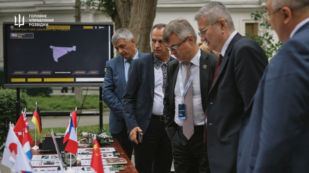Foreign diplomats examine Russian drone components and circuit boards labeled by country of origin, including flags and detailed data sheets. (Source: Main Intelligence Directorate) Foreign diplomats examine Russian drone components and circuit boards labeled by country of origin, including flags and detailed data sheets. (Source: Main Intelligence Directorate)