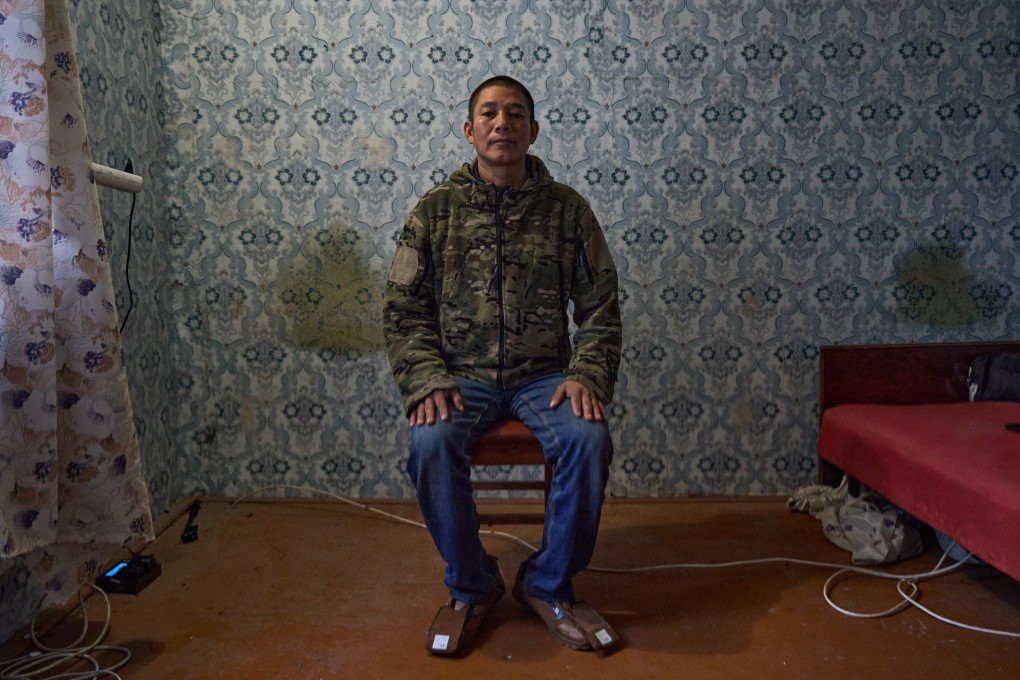 Peruvian prisoner of war (POW) Americo Valdivia Teco details the conditions he faced upon arriving in Moscow. Valdivia Teco explained that his passport was immediately confiscated by the recruiting agent, who isolated him and his travel companions in a hotel with only one meal a day before forcing them to sign military contracts they could not understand. (Photo: Mykyta Shandyba / UNITED24 Media) Peruvian POW Americo Valdivia Teco sits on a stool and explains how a Russian agent confiscated his passport and confined him to a hotel before forcing him to sign an illegible military contract.