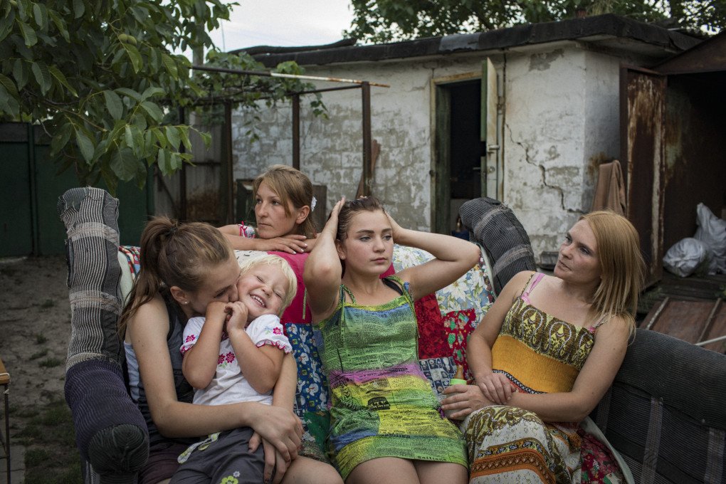 (L-R) Oleksandra Mountyan, Myroslava Hrynyk, Olha Grinik, Viktoriia Mountyan and Valentyna Mountyan—all members of an extended family—hanging out in the backyard of Olha’s house, located 50 meters from a Ukrainian military position in old Avdiivka, 2018. From the series 5K from the Frontline. (Image: Anastasia Taylor-Lind) (L-R) Oleksandra Mountyan, Myroslava Hrynyk, Olha Grinik, Viktoriia Mountyan and Valentyna Mountyan—all members of an extended family—hanging out in the backyard of Olha’s house, located 50 meters from a Ukrainian military position in old Avdiivka, 2018. From the series 5K from the Frontline. (Image: Anastasia Taylor-Lind)