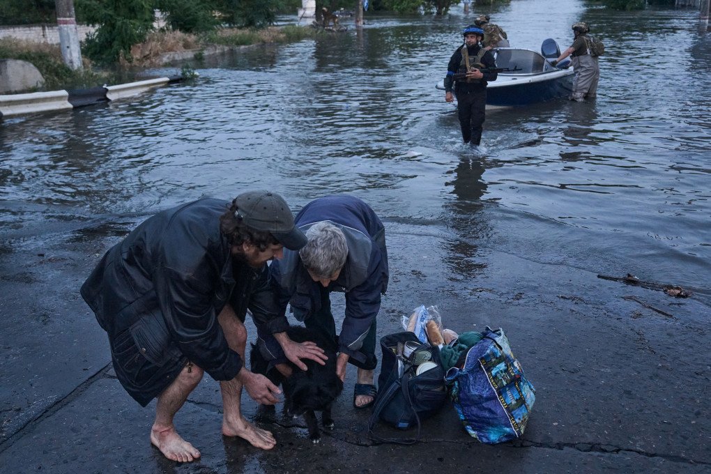 KHERSON REGION, UKRAINE - JULY, 2023: Russia blew up the Kakhovka Dam in the Kherson Region of Ukraine, causing catastrophic flooding of hundreds of Ukrainian villages and towns. This image pictures the evacuation of a local resident—with their pet and belongings—as Ukrainian volunteers rushed to the affected area to help thousands of people and animals whose homes were flooded by water. (LIBKOS)