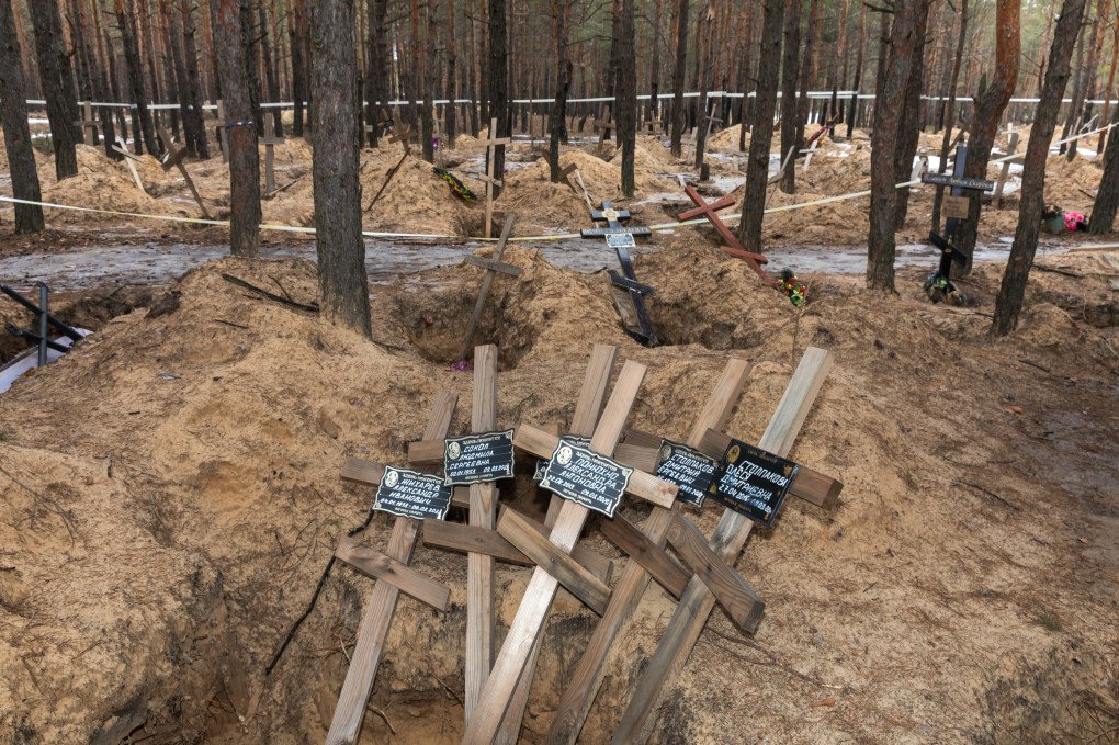IZIUM, UKRAINE - March 3, 2023: Crosses bearing the names of people killed by Russia are pictured lying among pines at a mass grave site near Izium. They serve as a testament to the atrocities committed during Russia’s occupation of the town, with the forest now holding only crosses and empty pits. Ater Izium's liberation by the Ukrainian forces, Ukrainian law enforcement exhumated 450 bodies, most of them civillians, from the mass grave. (Photo by Mykhaylo Palinchak/SOPA Images/LightRocket via Getty Images)