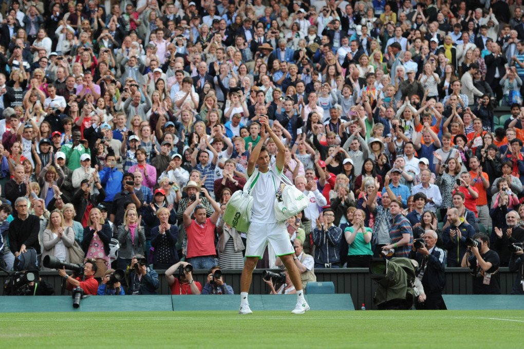 Stakhovsky applauds the fans after his victory against Federer on Wimbledon. Photo: Ben Radford/Corbis via Getty Images.