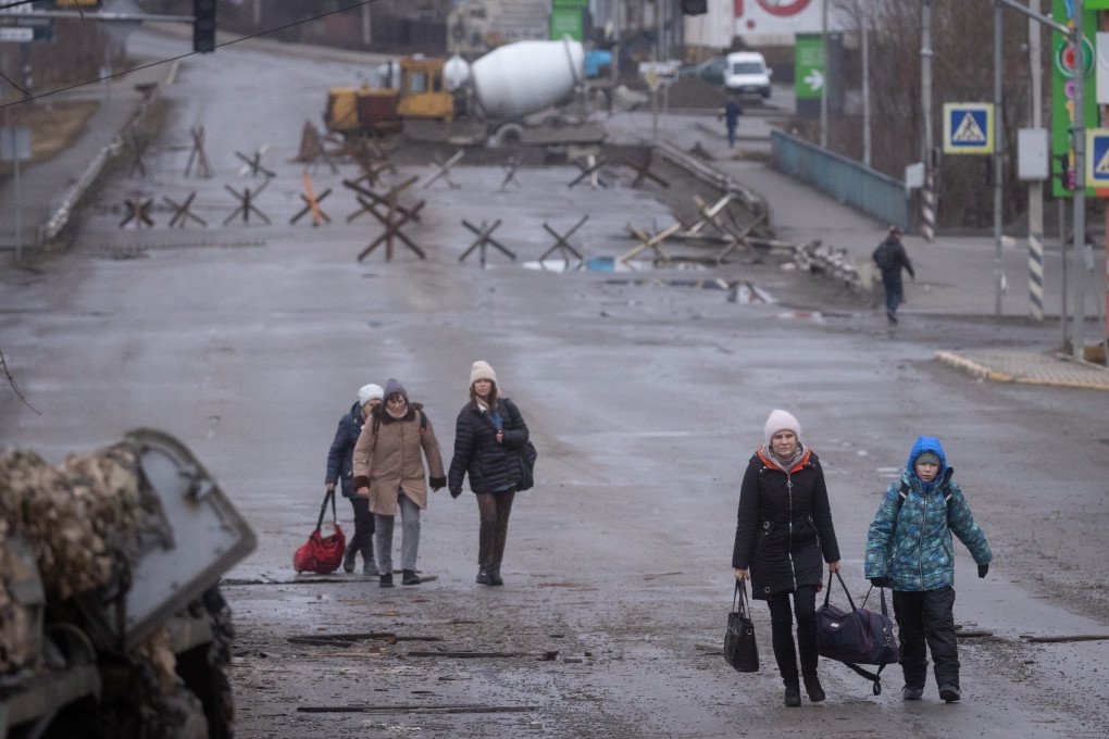 Civilians carry their belongings as the evacuate to safety across a contested bridge at the frontline between Bucha and Irpin on March 04, 2022 in Irpin, Ukraine. Photo by Chris McGrath/Getty Images