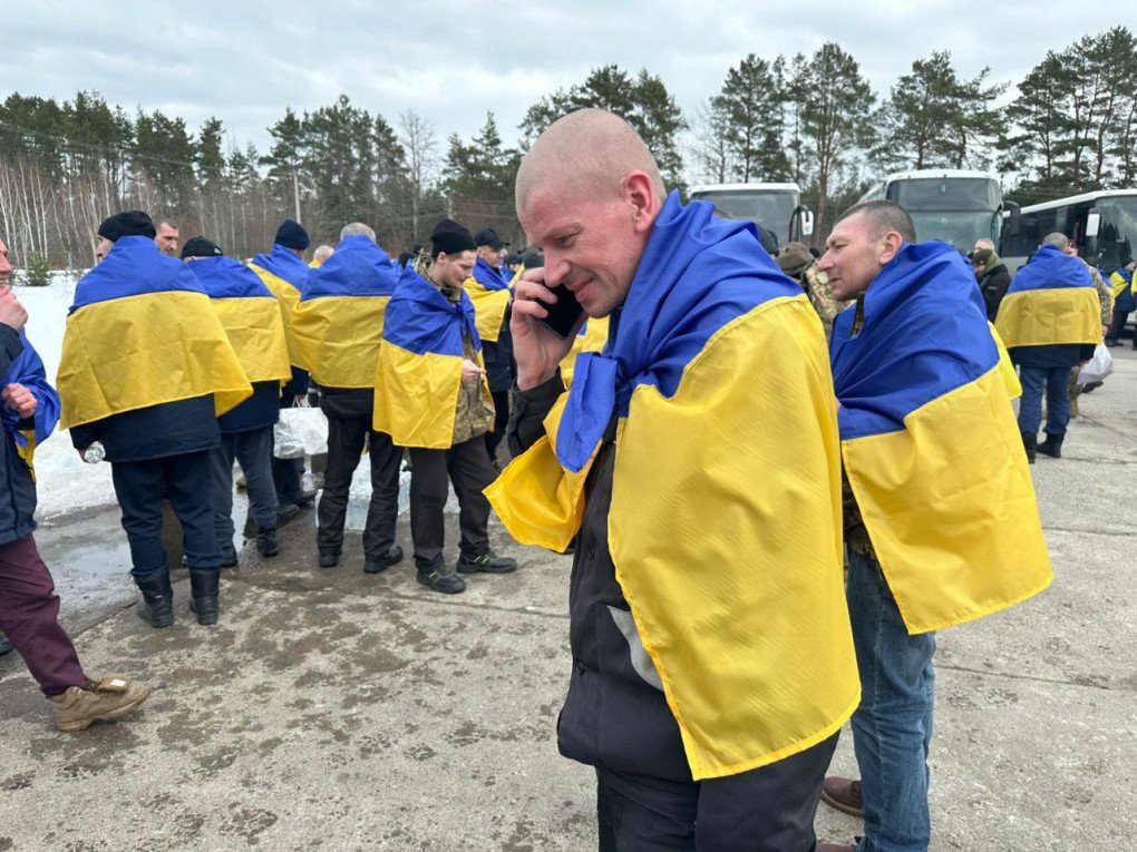 Militares ucranianos recientemente liberados del cautiverio ruso se encuentran cerca de autobuses tras regresar a territorio controlado por Ucrania durante un intercambio de prisioneros, el 6 de marzo de 2026. (Foto: Cuartel General de Coordinación para el Tratamiento de los Prisioneros de Guerra)