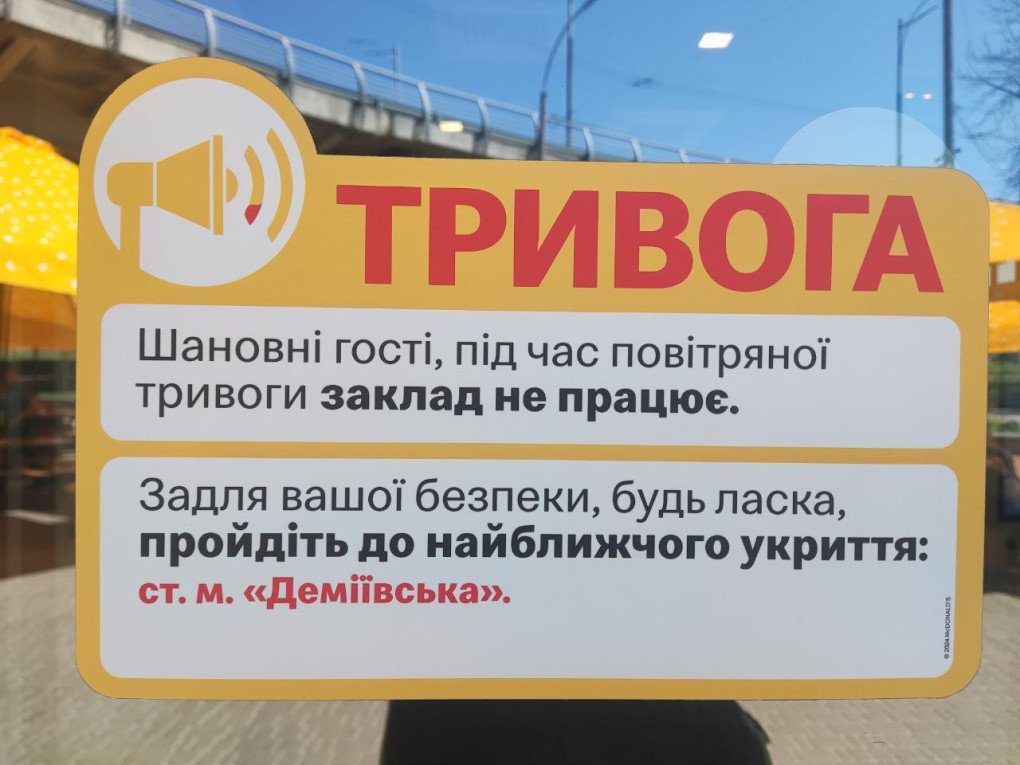 Un cartel en la puerta de McDonald's dice: «Estimados clientes, durante una alerta antiaérea, el establecimiento permanece cerrado. Por su seguridad, diríjase al refugio más cercano: la estación de metro Demiivska». Julio de 2025, Kiev. Foto: United24 Media. Un cartel en la puerta de McDonald's dice: «Estimados clientes, durante una alerta antiaérea, el establecimiento permanece cerrado. Por su seguridad, diríjase al refugio más cercano: la estación de metro Demiivska». Julio de 2025, Kiev. Foto: United24 Media.