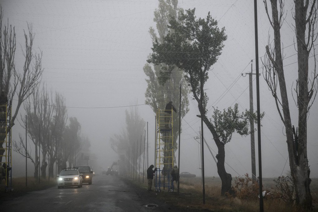 Trabajadores ucranianos instalan redes para protegerse de los ataques con drones FPV rusos cerca de Kramatorsk, en la región de Donetsk, el 10 de octubre de 2025, en medio de la invasión rusa de Ucrania. (Foto de ED JONES/AFP vía Getty Images)