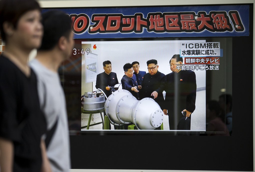 Pedestrians walk past a monitor showing an image of North Korean leader Kim Jong-Un in a news program reporting on North Korea's 6th nuclear test on September 3, 2017 in Tokyo, Japan. (Photo by Tomohiro Ohsumi via Getty Images)