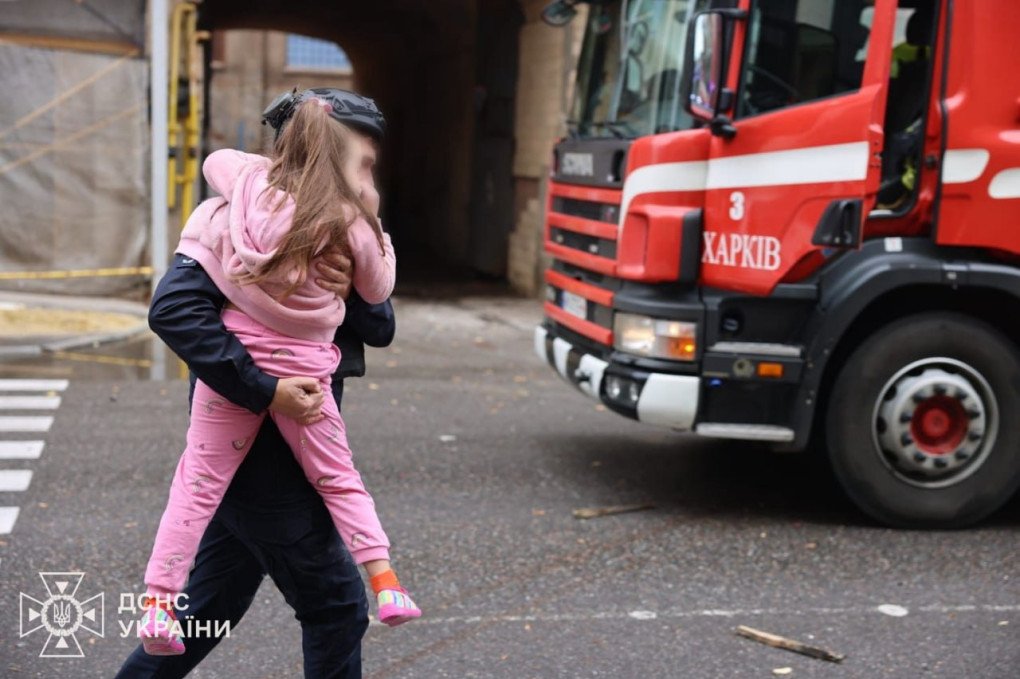 An emergency worker comforts a young child during evacuation efforts following the Russian strike on the Kharkiv kindergarten. (Source: Ukrainian President Volodymyr Zelenskyy)