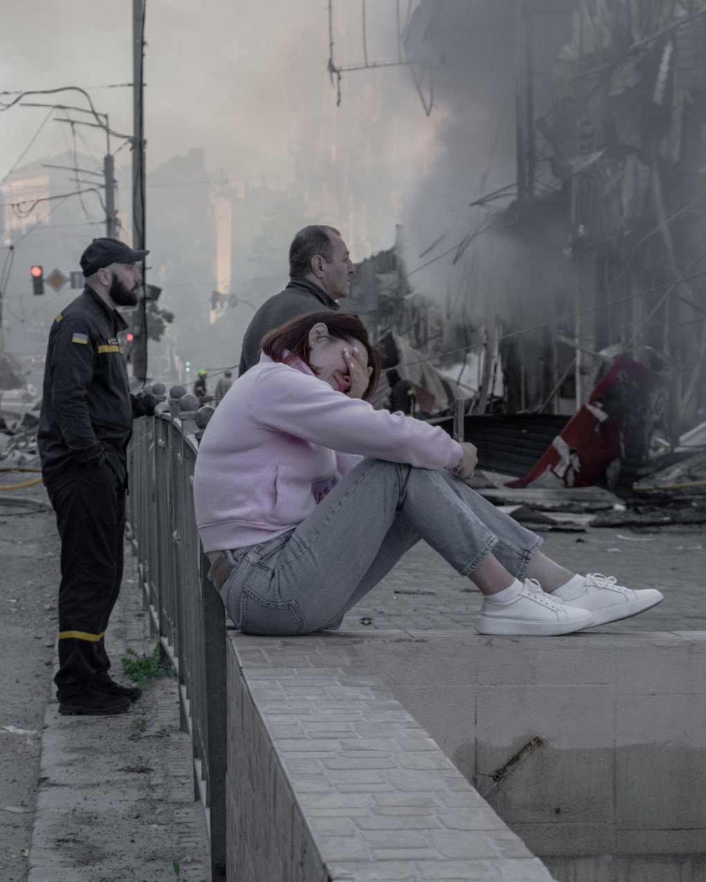 Una mujer llora frente a un edificio destruido en Kyiv, con los bomberos aún trabajando entre humo y escombros tras la oleada rusa de misiles y drones. (Foto: Nikita Lysovyi) Mujer sentada junto a una zona dañada en Kyiv mientras rescatistas trabajan tras el ataque ruso.