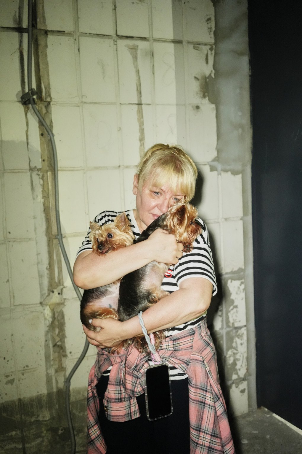 Woman holding her pets near a site of a Russian strike on a civilian house, Kyiv, July 10, 2025. Photo: Josh Olley