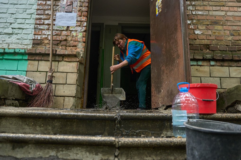 Un trabajador municipal limpia el barro y los escombros de la entrada de un edificio residencial en Kyiv tras el ataque nocturno de Rusia con drones y misiles el 7 de mayo de 2025.
