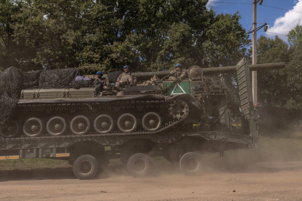 Ukrainian servicemen sit on a self-propelled artillery 2S7 Pion while being carried by a military truck, in the Sumy region, near the border with Russia, on August 11, 2024, amid the Russian invasion of Ukraine. (Source: Getty Images) Ukrainian servicemen sit on a self-propelled artillery 2S7 Pion while being carried by a military truck, in the Sumy region, near the border with Russia, on August 11, 2024, amid the Russian invasion of Ukraine. (Source: Getty Images)
