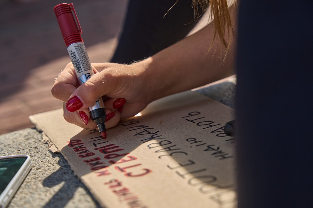 A protester writes a message on a handmade cardboard sign before the demonstration outside the Office of the President in Kyiv, where thousands gathered to oppose Mykhailo Fedorov’s removal as defense minister. Photo: Mykyta Shandyba/UNITED24 Media A protester writes a message on a handmade cardboard sign before the demonstration outside the Office of the President in Kyiv, where thousands gathered to oppose Mykhailo Fedorov’s removal as defense minister. Photo: Mykyta Shandyba/UNITED24 Media