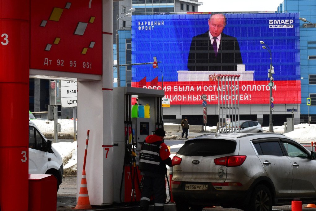 En la fachada de un edificio se proyecta la transmisión del discurso anual sobre el estado de la nación del presidente ruso Vladimir Putin, mientras un empleado llena el tanque de un automóvil en una gasolinera de Moscú el 29 de febrero de 2024. (Foto de Olga Maltseva/AFP vía Getty Images) En la fachada de un edificio se proyecta la transmisión del discurso anual sobre el estado de la nación del presidente ruso Vladimir Putin, mientras un empleado llena el tanque de un automóvil en una gasolinera de Moscú el 29 de febrero de 2024. (Foto de Olga Maltseva/AFP vía Getty Images)