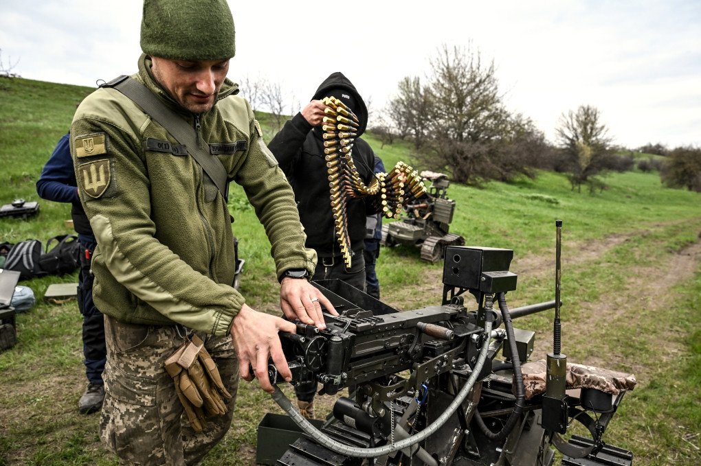 A soldier loads a machine gun mounted on a ground robotic complex during trials at a training ground, April 10, 2026. (Photo by Dmytro Smolienko via Getty Images)