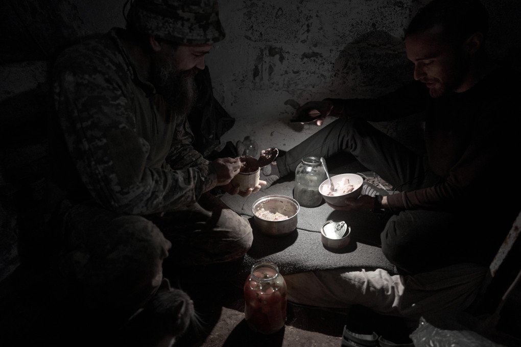 Dos soldados ucranianos cenan juntos en un refugio subterráneo en la ciudad fronteriza de Kostiantynivka, Ucrania, el 16 de octubre de 2025. La ciudad yace en ruinas tras meses de implacables ataques rusos, con edificios destruidos, calles desiertas y vestigios de la presencia militar y de la supervivencia civil visibles por toda la zona. (Foto de Kostiantyn Liberov/Libkos/Getty Images)