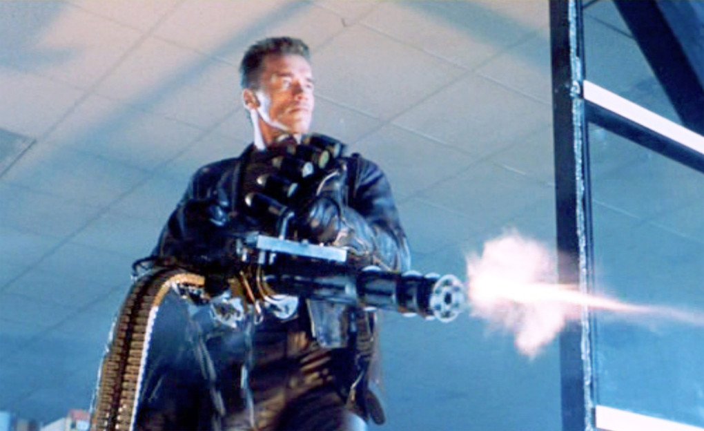 Screen capture from the movie “Terminator 2: Judgment Day.” Arnold Schwarzenegger (as the T-800 Terminator). He fires a handheld minigun. (Source: Getty Images)