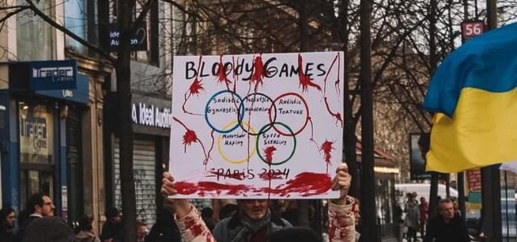 A protestor holds a sign reading "Bloody Games" during a demonstration in Paris ahead of the 2024 Summer Olympics, condemning the participation of Russian and Belarusian athletes amidst the ongoing war in Ukraine. (Source: Ukrainian World Congress)