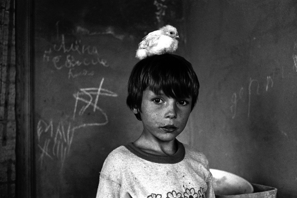 On the doorstep of the Martynenko family’s family-type orphanage. Vova with a chick he was caring for. Odesa, 2001. Vova now serves in the Ukrainian Armed Forces. 