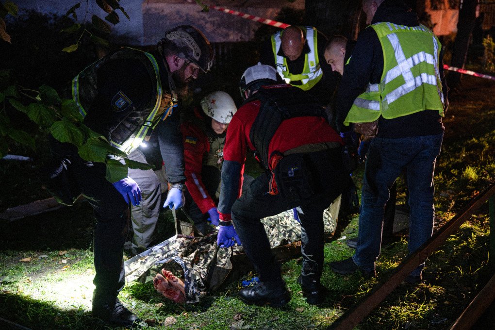 Ukrainian police and paramedics carry the body of a victim at the site of a Russian missile strike at an apartment building in Kyiv on October 14, 2026, amid the Russian invasion of Ukraine. (Photo by Genya Savilov via Getty Images)