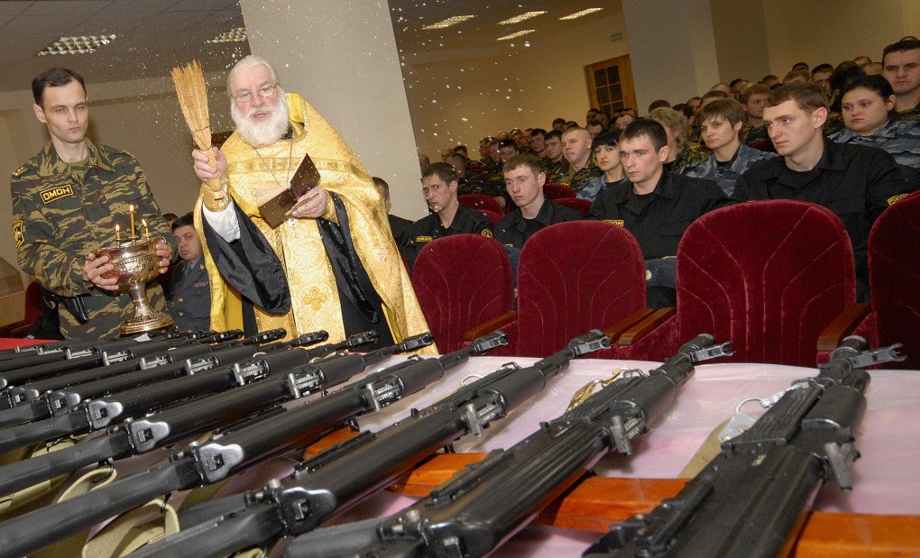 A Russian Orthodox priest blesses new Kalashnikov machine guns during a ceremony presenting the new weapons to recently enlisted members of Russia’s elite “OMON” riot police corps in Stavropol, 29 January 2008. (Source: Getty Images) A Russian Orthodox priest blesses new Kalashnikov machine guns during a ceremony presenting the new weapons to recently enlisted members of Russia’s elite “OMON” riot police corps in Stavropol, 29 January 2008. (Source: Getty Images)