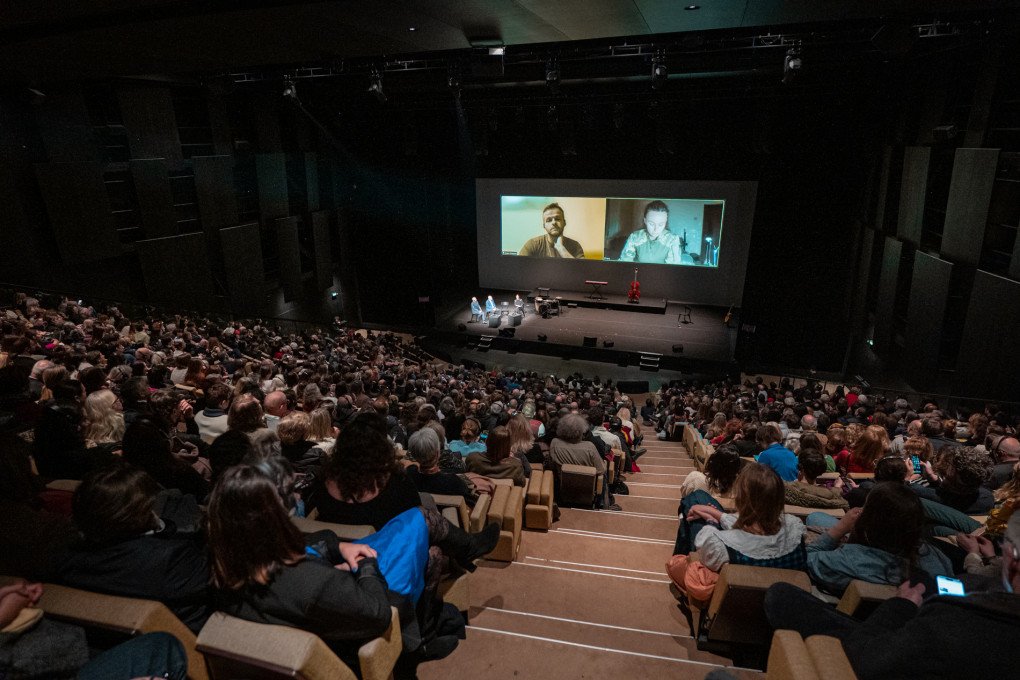 A full house at Théâtre de la Ville–Sarah Bernhardt watches a live-streamed conversation with Ukrainian participants during the opening night of Le Voyage en Ukraine. (Source: Mathis Queraux / Ukrainian Institute in France)