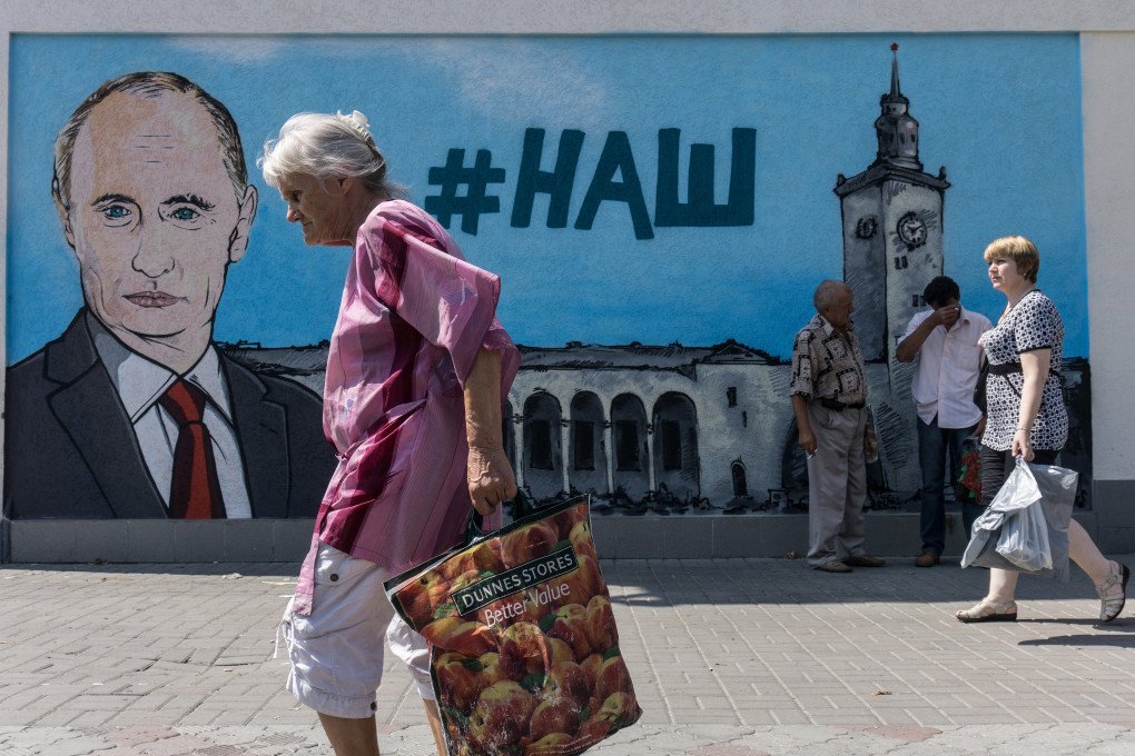 People walk past a mural depicting Vladimir Putin alongside the hashtag #НАШ (“Ours”), referring to Russia’s claim over the illegally annexed Crimean peninsula, in Russian-occupied Simferopol, Ukraine, on August 17, 2015. The mural was painted by Moscow-based artists with the approval of Russian-installed authorities. (Photo: Alexander Aksakov via Getty Images) People walk past a mural depicting Vladimir Putin alongside the hashtag #НАШ (“Ours”), referring to Russia’s claim over the illegally annexed Crimean peninsula, in Russian-occupied Simferopol, Ukraine, on August 17, 2015. The mural was painted by Moscow-based artists with the approval of Russian-installed authorities. (Photo: Alexander Aksakov via Getty Images)