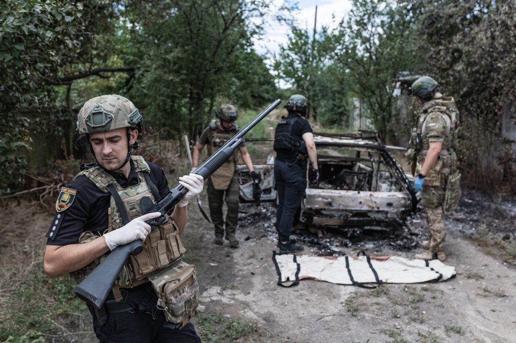 Paramedics and police collect the remains of a civilian burned inside a car after it is struck by a Russian FPV drone in Kostiantynivka, Ukraine, on August 14, 2025. (Source: Getty Images)