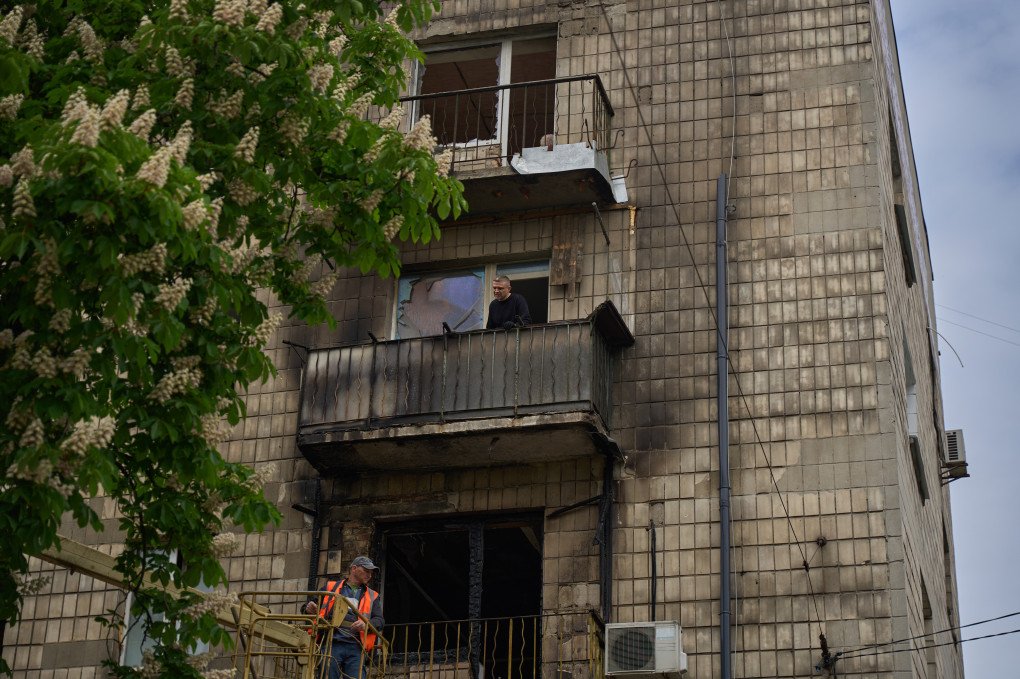 Los residentes evalúan los daños en sus balcones después de que un ataque ruso provocara un incendio en este edificio de apartamentos de Kyiv el 7 de mayo de 2025.