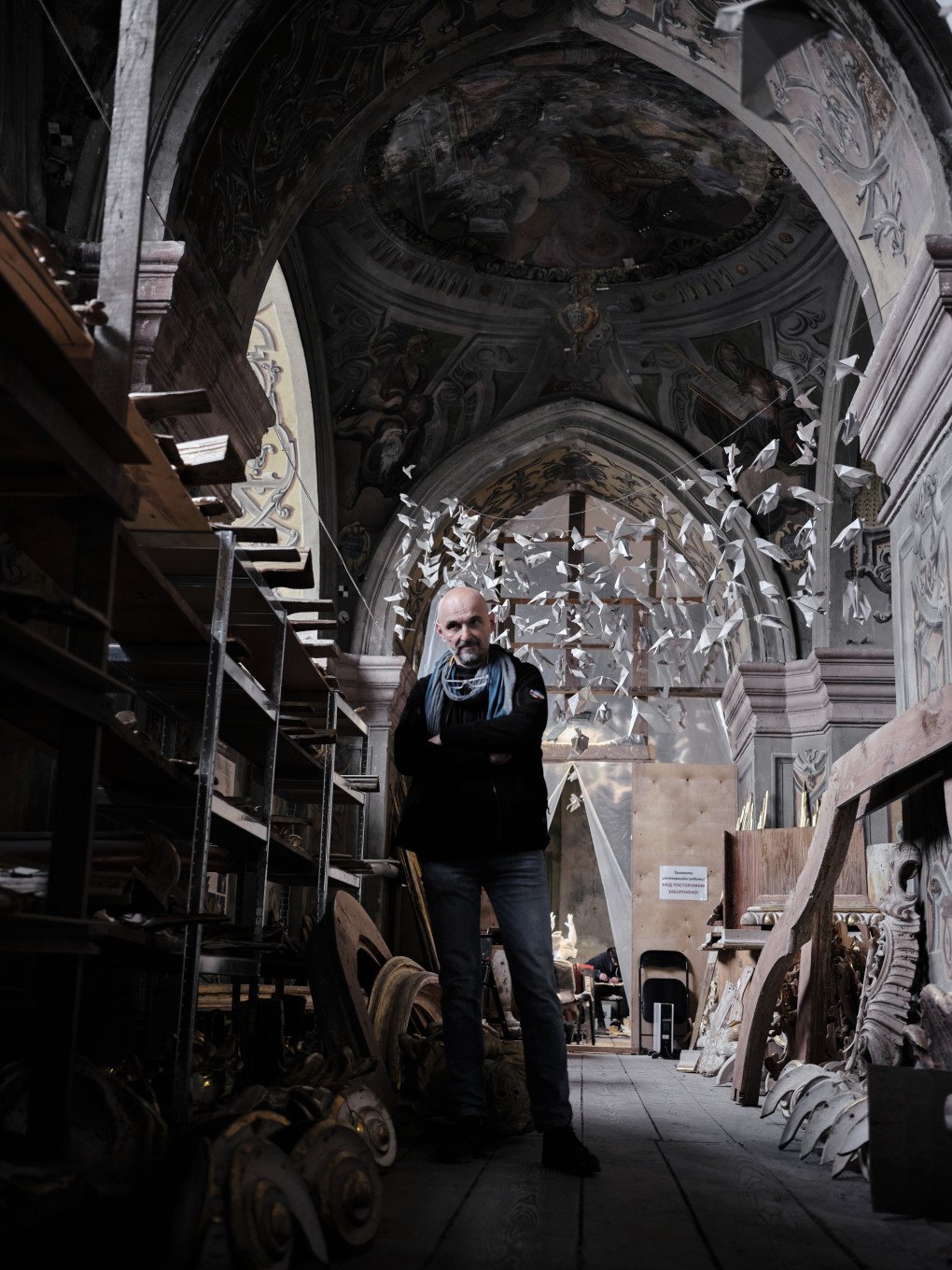 Dr. Boliński stands on the upper level of the church, where many gilded items await restoration. Above him, paper birds made by children in 2014 for the defenders of Ukraine still hang today. Dr. Boliński has led the church’s conservation efforts since they began in 2012. Dr. Boliński stands on the upper level of the church, where many gilded items await restoration. Above him, paper birds made by children in 2014 for the defenders of Ukraine still hang today. Dr. Boliński has led the church’s conservation efforts since they began in 2012.