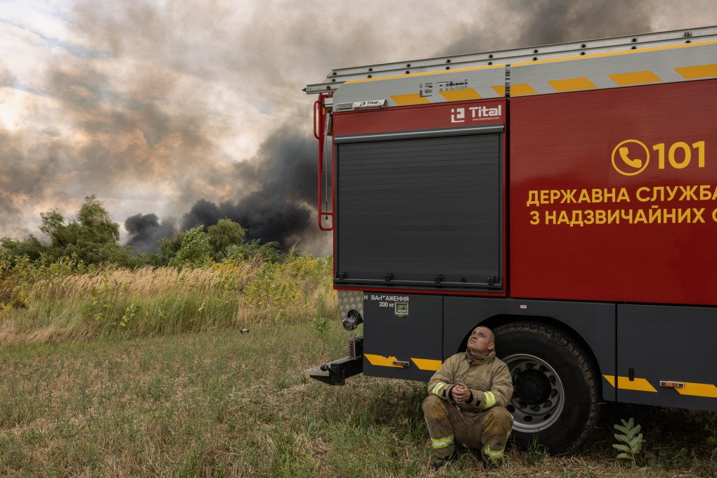 A firefighter scans the sky for drones while waiting to return to a warehouse fire, after being pulled back from the scene over fears of a double-tap strike in Boryspil district on August 27, 2026 in Kyiv, Ukraine. Drones hit a warehouse and home, while others were intercepted. The Ukrainian Air Force had earlier detected ballistic missiles heading toward the Ukrainian capital. (Photo by Diego Fedele via Getty Images)